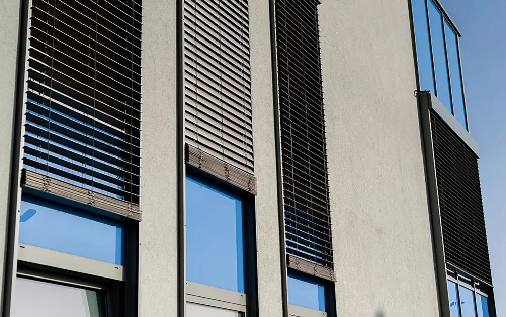 Hausfassade mit Raffstoren vor mehreren Fenstern